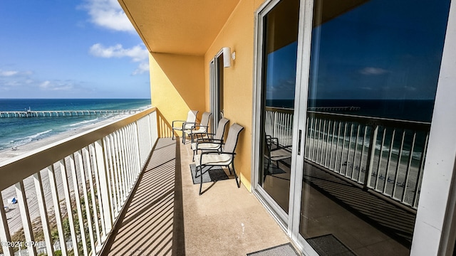 balcony featuring a beach view and a water view