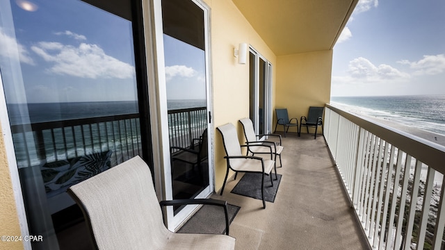 balcony featuring a beach view and a water view