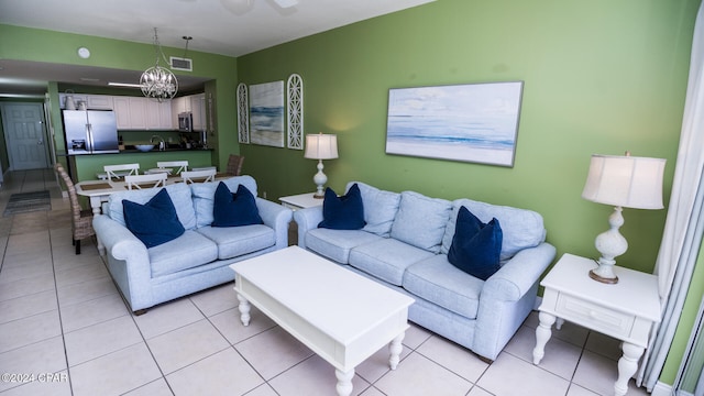 living room featuring light tile patterned floors and ceiling fan with notable chandelier