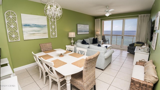 15817 Front Beach Rd Unit 1-906, Panama City Beach, FL 32413 - dining room with a water view, light tile patterned floors, a chandelier, a ceiling fan, and baseboards