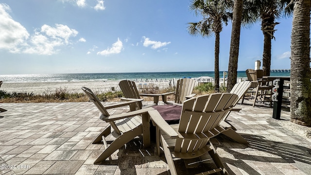 view of patio featuring a beach view and a water view