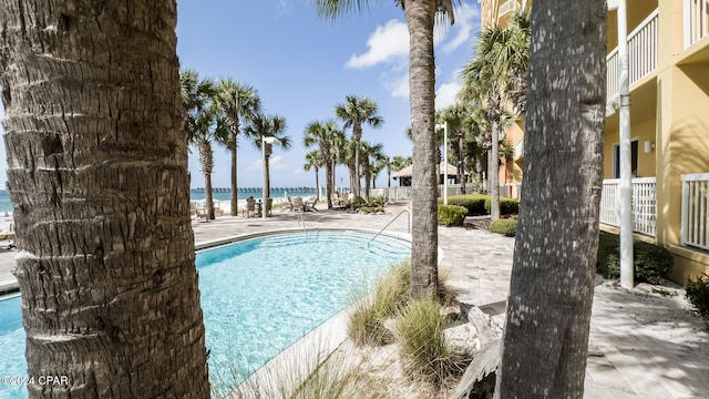 view of swimming pool with a patio area and a water view