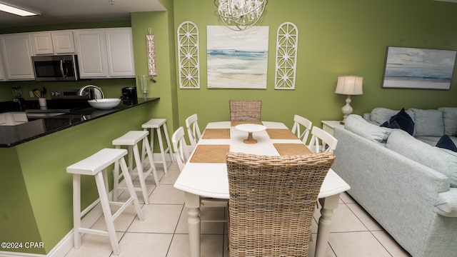 tiled dining room featuring an inviting chandelier