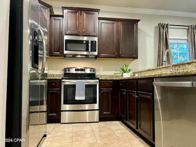 kitchen with light stone counters, stainless steel appliances, dark brown cabinetry, and crown molding