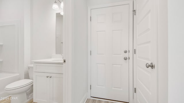 bathroom with toilet, hardwood / wood-style flooring, and vanity