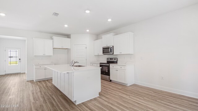 kitchen featuring light hardwood / wood-style floors, white cabinets, a kitchen island with sink, and stainless steel appliances