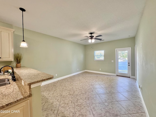 interior space with a textured ceiling, ceiling fan, and sink