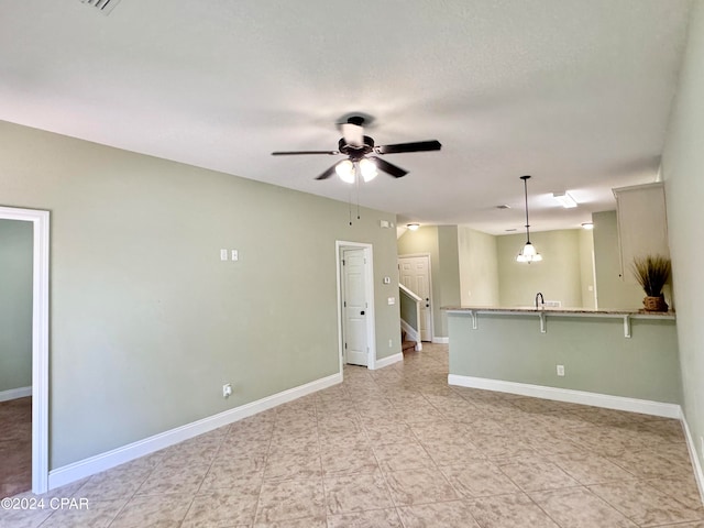 spare room with ceiling fan with notable chandelier