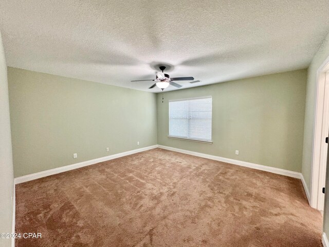 carpeted spare room featuring ceiling fan and a textured ceiling