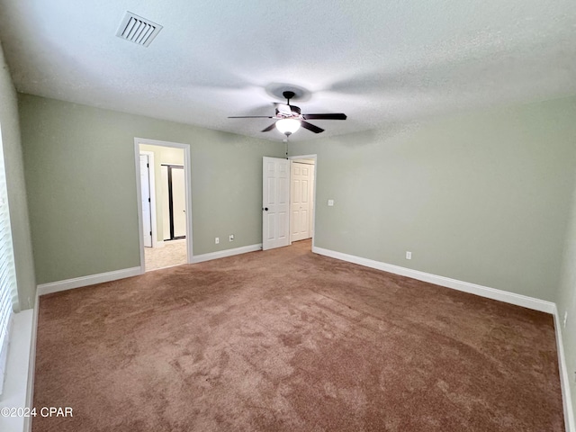 unfurnished bedroom featuring carpet flooring, ceiling fan, and a textured ceiling