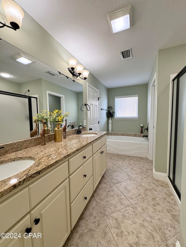 bathroom featuring plus walk in shower, a textured ceiling, vanity, and tile patterned floors