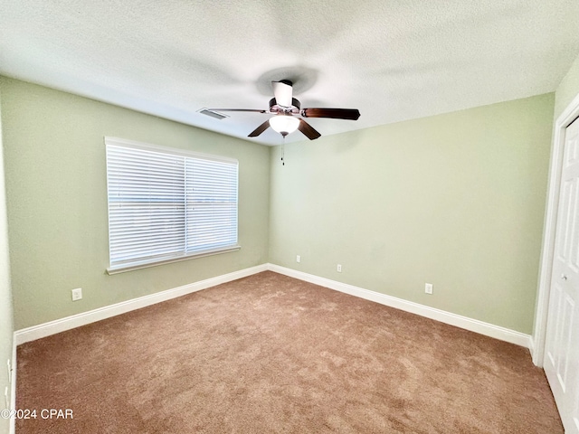 unfurnished bedroom featuring ceiling fan, a closet, carpet floors, and a textured ceiling