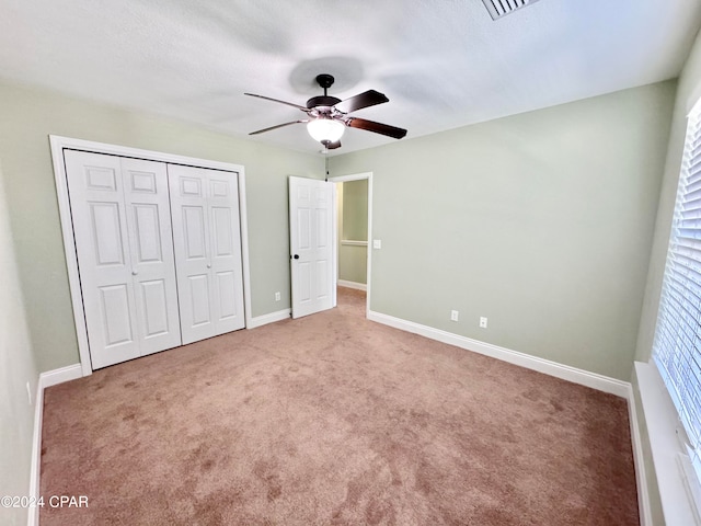 unfurnished bedroom with ceiling fan, carpet floors, and a closet