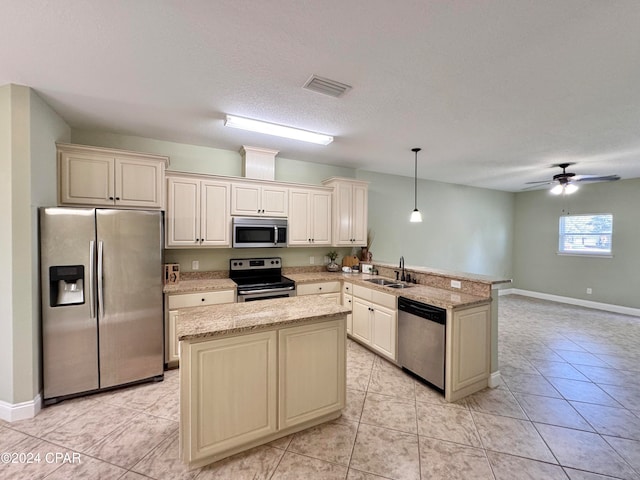 kitchen featuring pendant lighting, a kitchen island, sink, and appliances with stainless steel finishes