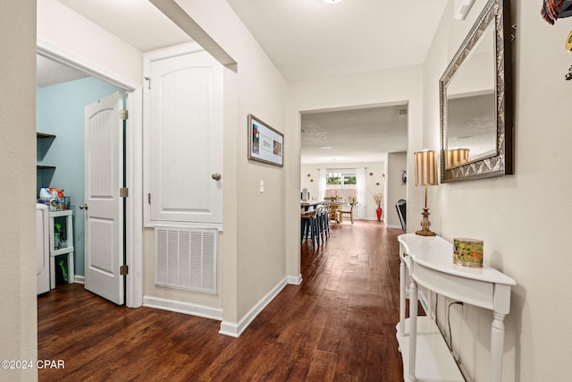 corridor with a textured ceiling and dark hardwood / wood-style floors