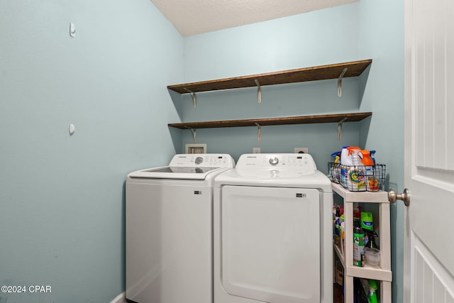 clothes washing area featuring washer and dryer and a textured ceiling