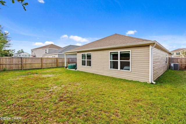 back of property featuring a yard and central AC