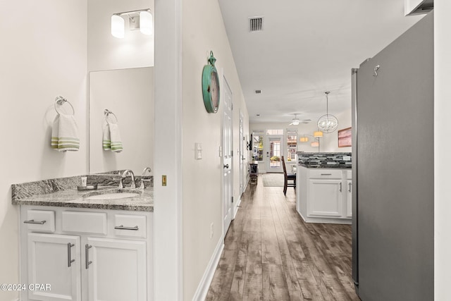 corridor with hardwood / wood-style flooring and sink