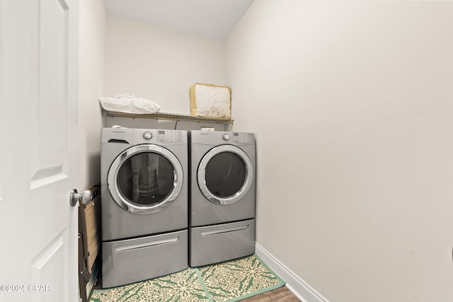 laundry area featuring hardwood / wood-style flooring and separate washer and dryer