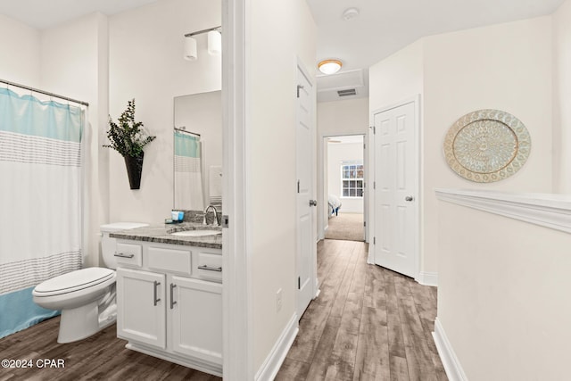 bathroom with vanity, toilet, and hardwood / wood-style flooring