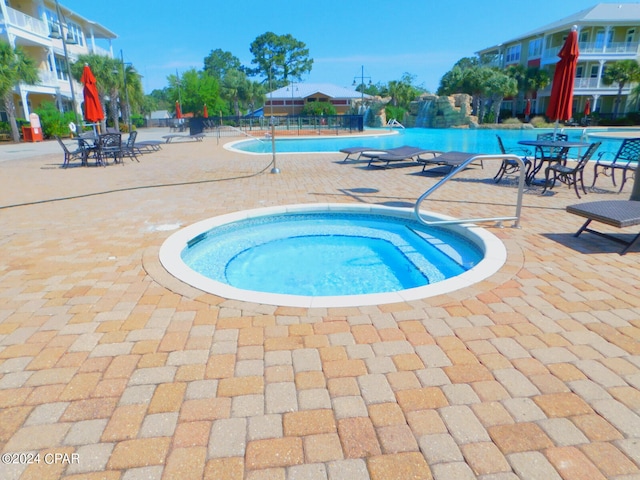 view of swimming pool featuring a patio area and a community hot tub