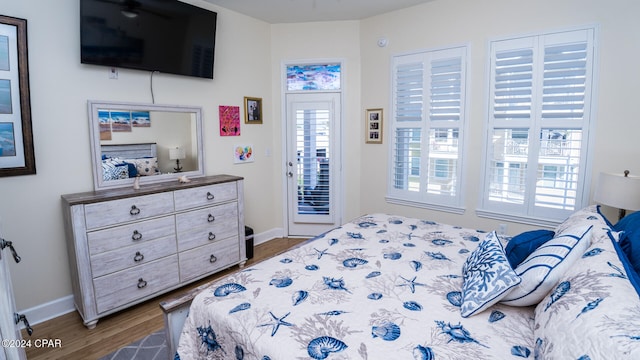 bedroom with access to outside and dark hardwood / wood-style floors