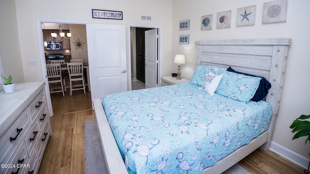 bedroom featuring a notable chandelier and wood-type flooring