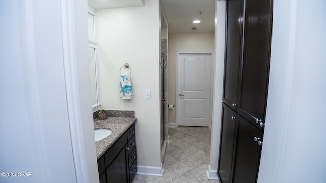 bathroom with tile patterned flooring, vanity, and a shower with door