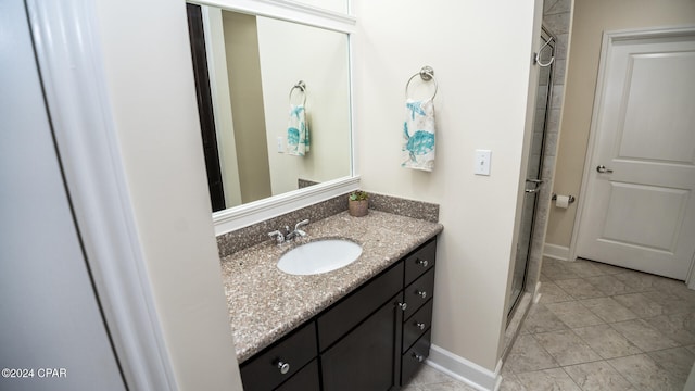 bathroom featuring tile patterned flooring, vanity, and walk in shower