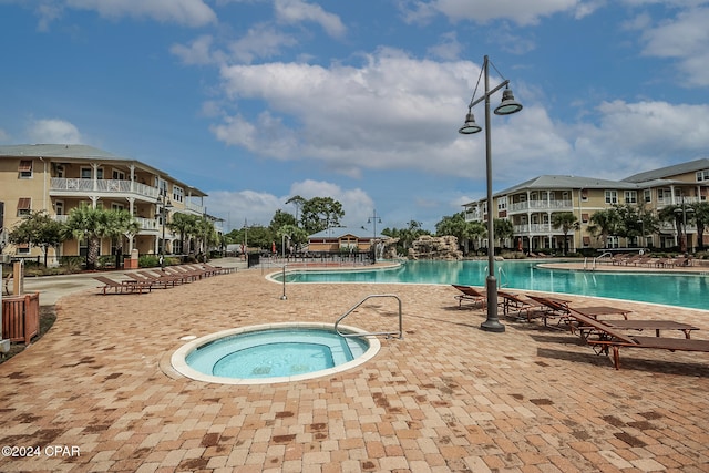 view of pool with a patio area and a community hot tub