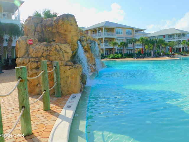 view of swimming pool with pool water feature