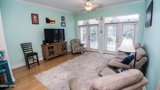 living room with baseboards, a ceiling fan, crown molding, french doors, and light wood-type flooring