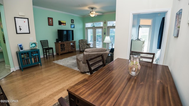 dining space with french doors, ornamental molding, wood finished floors, and a healthy amount of sunlight