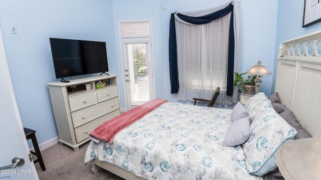 carpeted bedroom with access to exterior and baseboards