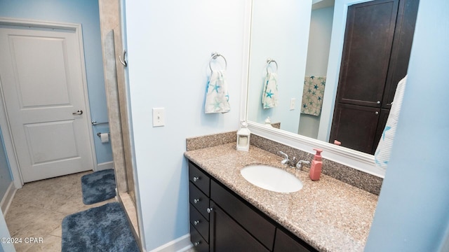 bathroom with tile patterned flooring, a shower stall, vanity, and baseboards