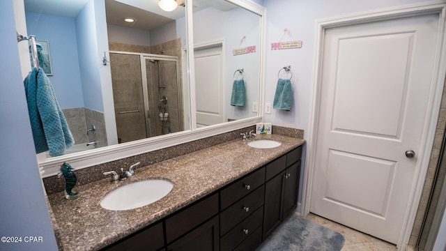 full bath featuring a stall shower, a sink, and double vanity