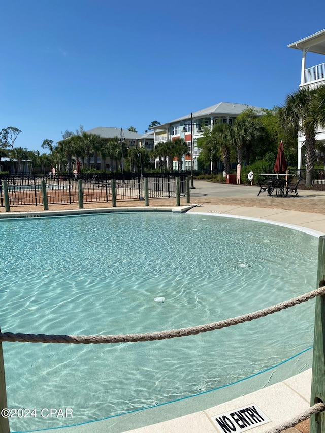 community pool with fence and a patio