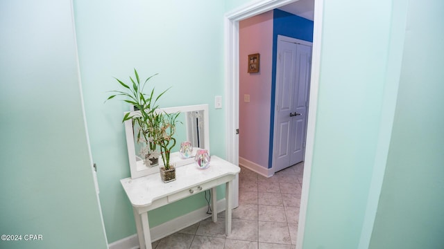 hallway featuring light tile patterned flooring and baseboards