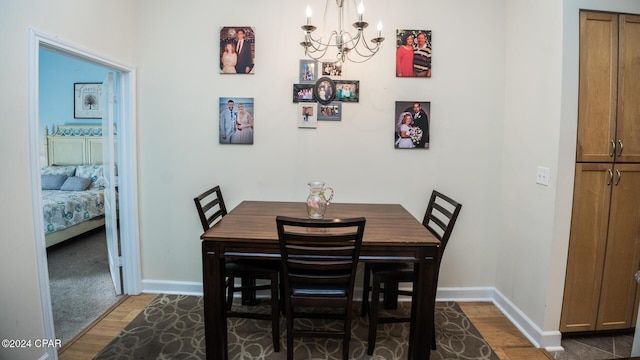 dining room with baseboards, dark wood-type flooring, and an inviting chandelier