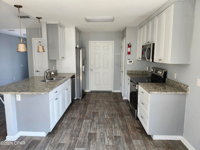 kitchen featuring pendant lighting, white cabinets, dark hardwood / wood-style flooring, kitchen peninsula, and stainless steel appliances