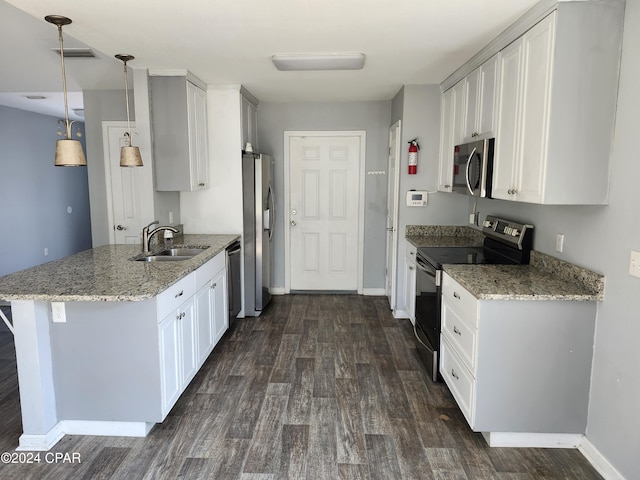 kitchen with pendant lighting, sink, white cabinets, kitchen peninsula, and stainless steel appliances