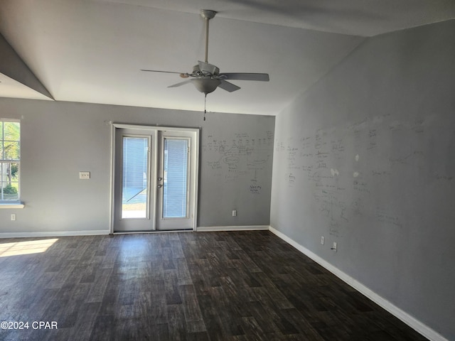 empty room with ceiling fan, lofted ceiling, dark wood-type flooring, and french doors