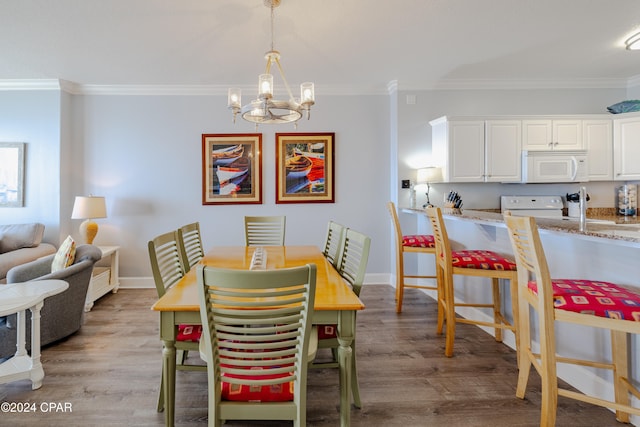 dining space with light hardwood / wood-style floors and ornamental molding