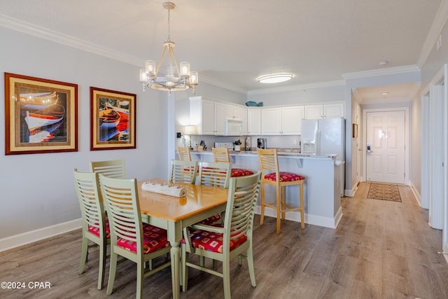 dining area featuring a notable chandelier, light hardwood / wood-style floors, and crown molding