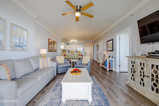 living room with ceiling fan with notable chandelier, hardwood / wood-style flooring, and ornamental molding