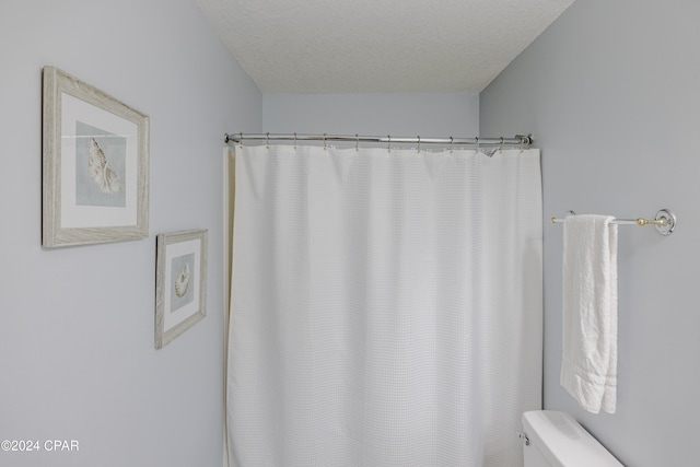 bathroom with a textured ceiling and toilet