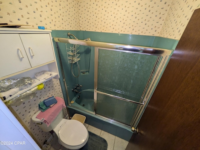 bathroom with tile patterned flooring, toilet, and shower / bath combination with glass door