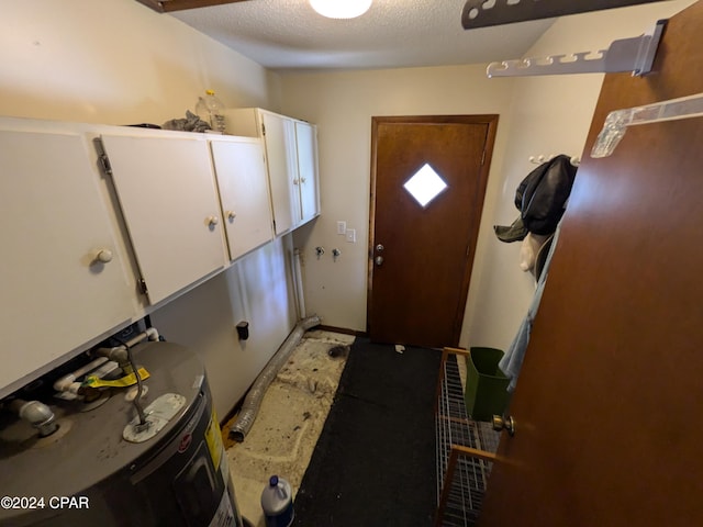 interior space with water heater and a textured ceiling