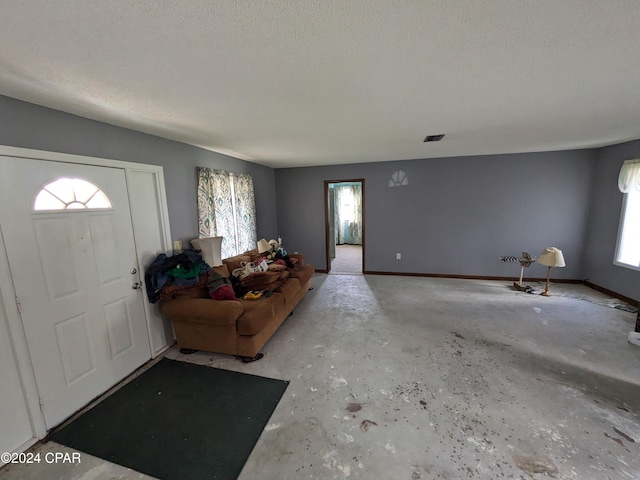 entryway featuring a wall mounted air conditioner and a textured ceiling