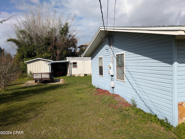 view of side of property featuring a shed and a yard